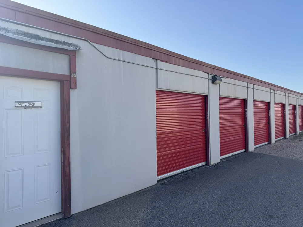 Access door beside red roll-up storage unit doors at Yukon Self Storage